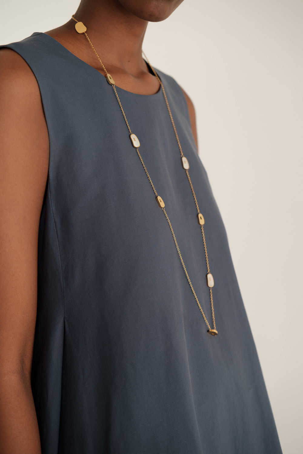 Woman in Blue Dress with Long Simple Necklace